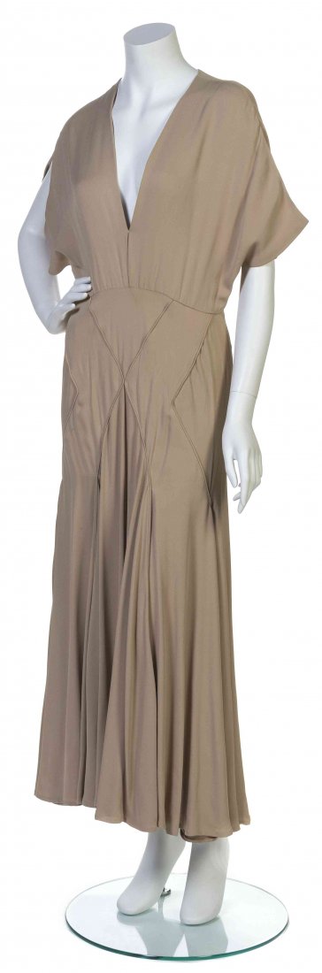 A Galanos Taupe Silk Crêpe Dress,: A Galanos Taupe Silk Crêpe Dress, slit sleeves with a deep-v neckline, diamond shaped piping to the flared skirt. Labeled: Galanos. Property from the Estate of Betsy Pickering Kaiser