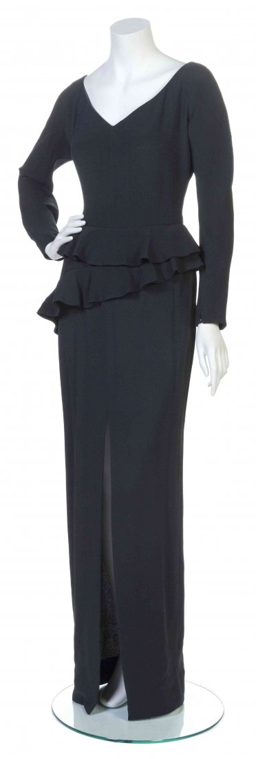 A Galanos Black Crêpe Gown,: A Galanos Black Crêpe Gown, zipper wrist long sleeves, with a V-neckline, two tier ruffle peplum to the front and a center front split hem. Labeled: Galanos. Property from the Estate of Betsy Pickeri