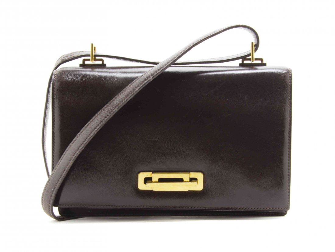 An Hermès Brown Leather Bag, 8 x 5 1/2 x 2 inches.: An Hermès Brown Leather Bag, leather shoulder strap with goldtone hardware. Stamped: Hermès / Made in France for Bonwit Teller. 8 x 5 1/2 x 2 inches. Property from the Estate of Betsy Pickering Kais
