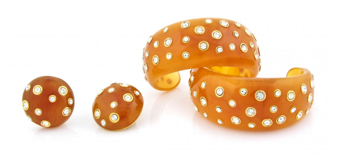 A Pair of Kenneth Jay Lane Faux Amber Resin and: A Pair of Kenneth Jay Lane Faux Amber Resin and Rhinestone Bangles, together with a pair of faux amber resin and rhinestone earclips. All stamped: Kenneth Lane. Property from the Estate of Betsy Picke