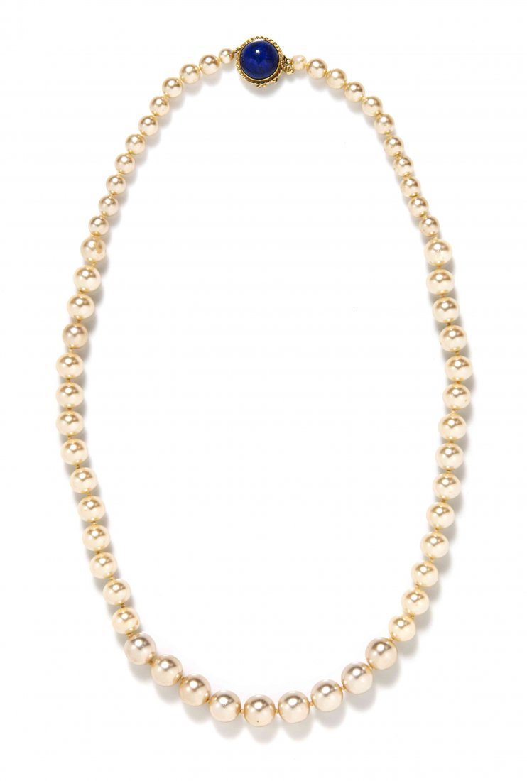 A 14 Karat Yellow Gold Lapis Lazuli and Graduated Faux: A 14 Karat Yellow Gold Lapis Lazuli and Graduated Faux Pearl Necklace, consisting of a round cabochon cut lapis and a 14 karat yellow gold clasp. Stamped: 14 Kt. Property from the Estate of Betsy Pick