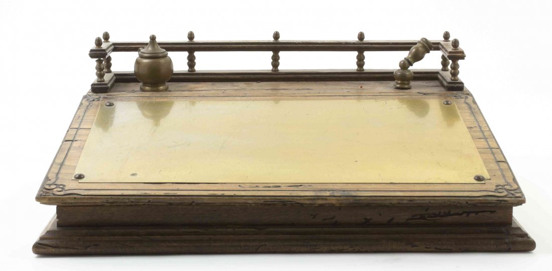 A Brass and Mahogany Lap Desk, Width 17 inches.: A Brass and Mahogany Lap Desk, having a galleried top over the lift-top front, mounted with a brass writing surface, raised on a conforming base. Width 17 inches. Property from the Kenneth Laurent Hou