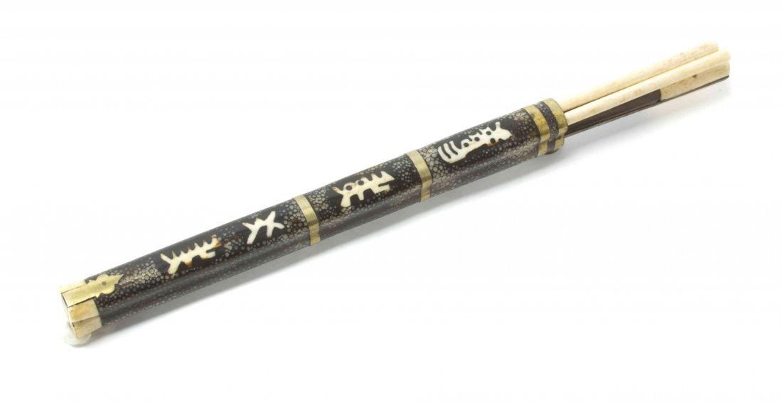 A Chinese Shagreen and Bone Utensil Case, Length: A Chinese Shagreen and Bone Utensil Case, comprising a knife and a pair of bone chopsticks, having brass mounts with inlaid character decoration. Length encased overall 10 3/4 inches.