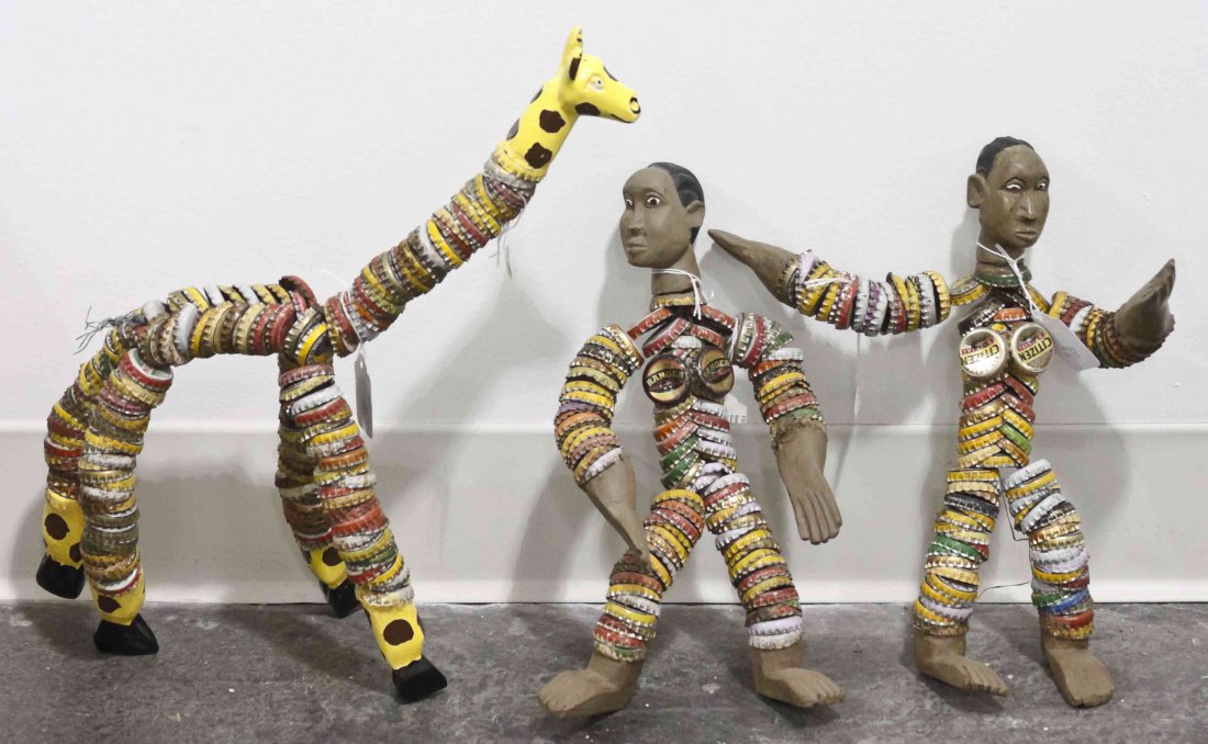 Three Kenyan Bottle Cap Figures, Height of tallest 20: Three Kenyan Bottle Cap Figures, two in the form of men and one in the form of a giraffe, each with painted faces and limbs. Height of tallest 20 inches. Property from the Collection of Gerald F. Glae