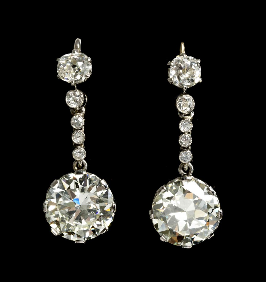 A Pair of Platinum and Diamond Earrings, 5.40 dwts.: A Pair of Platinum and Diamond Earrings, consisting of dangle pendants containing one round brilliant cut diamond weighing approximately 5.13 carats and one transitional brilliant cut diamond weighing