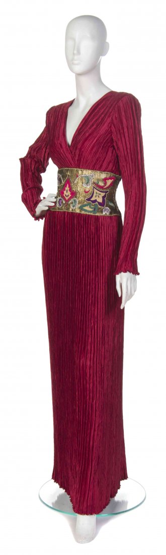 A Mary McFadden Burgundy Marii Pleated Gown, Size 8.: A Mary McFadden Burgundy Marii Pleated Gown, (American, b. 1938) long sleeves with a V-neckline and a gold sequin embroidered waist. Labeled: Mary McFadden. red pleated with multicolor embroidery size