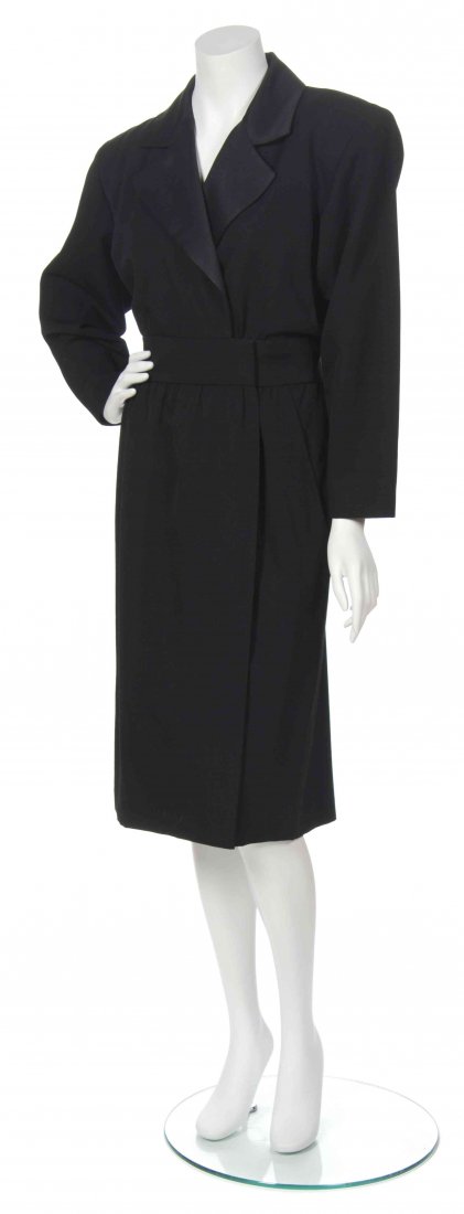 An Yves Saint Laurent Black Wool Coat Dress,: An Yves Saint Laurent Black Wool Coat Dress, circa 1980, with a silk lapel, wide band to the waist and asymmetric closure. Labeled: Saint Laurent Rive Gauche.