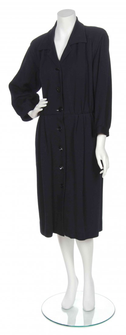 An Yves Saint Laurent Black Wool Coat Dress,: An Yves Saint Laurent Black Wool Coat Dress, circa 1980, cropped sleeves, button down front with a pintuck waist and side slit pockets. Labeled: Saint Laurent Rive Gauche.
