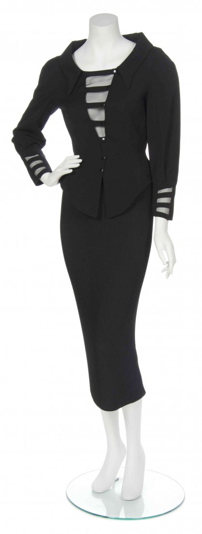 A Thierry Mugler Black Skirt Suit, Size 36.: A Thierry Mugler Black Skirt Suit, comprised of jacket with a sheer V-neck panel to the bust and a peplum waist together with a broomstick pleated midi skirt. Labeled: Thierry Mugler. Size 36.