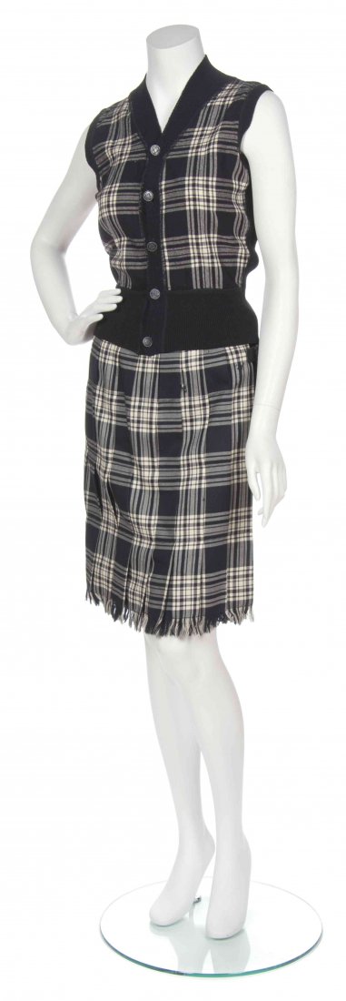 A Jean Paul Gaultier Black and Cream Wool Plaid Skirt: A Jean Paul Gaultier Black and Cream Wool Plaid Skirt Ensemble, circa 1980, comprised of a sleeveless button down vest together with a front pleated side buckle skirt, black knit backs to both. Labele