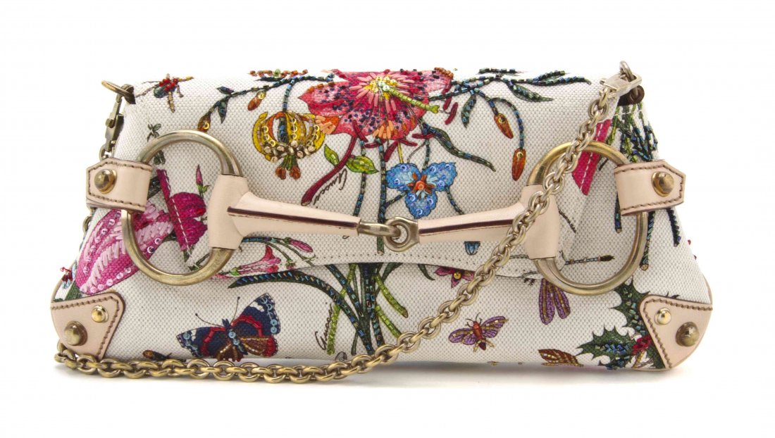 A Gucci Flora Print Canvas and Leather Clutch, 10 3/4 x: A Gucci Flora Print Canvas and Leather Clutch, fold over flap, goldtone hardware, bead embroidered surface, with a detachable goldtone chain link strap. Stamped: Gucci. 10 3/4 x 5 x 3/4 inches. Proper