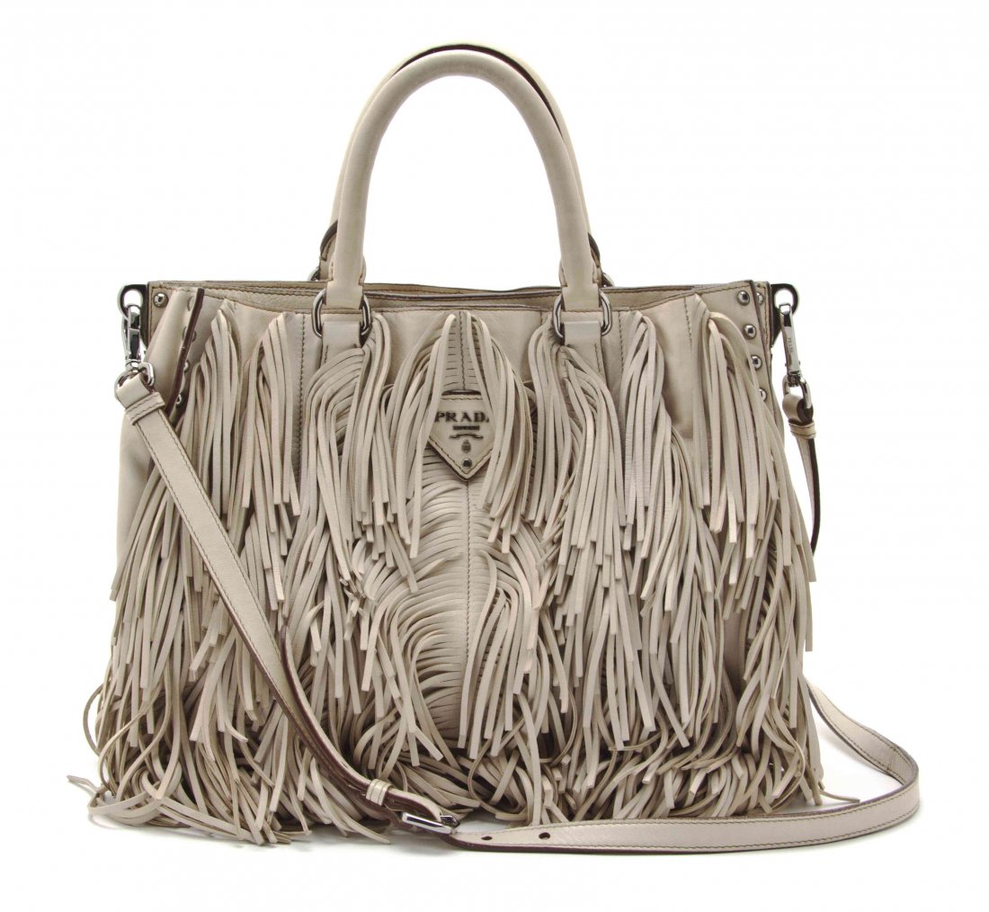 A Prada Beige Fringe Leather Bag, 11 1/2 x 10 x 4 1/2: A Prada Beige Fringe Leather Bag, 2007, two hand straps with silvertone hardware and silver grommets, two snap button compartments with detachable shoulder strap. Stamped: Prada. 11 1/2 x 10 x 4 1/2 i