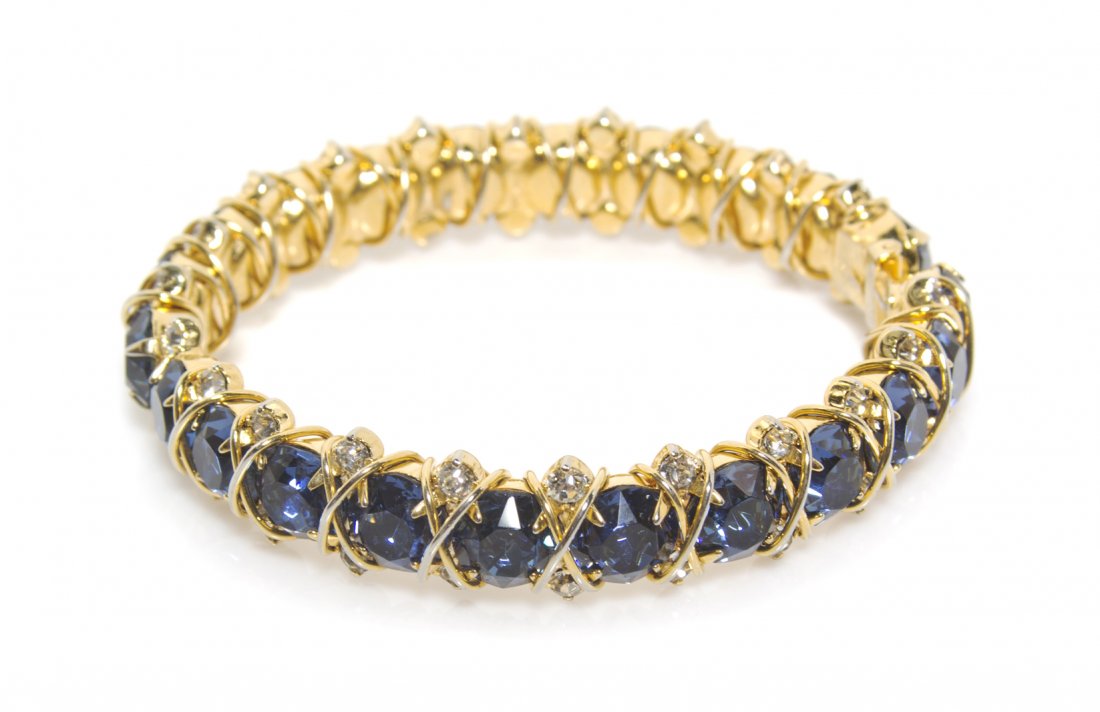 A Hattie Carnegie Faux Sapphire Hinged Bangle,: A Hattie Carnegie Faux Sapphire Hinged Bangle, with rhinestone accents in a goldtone setting. Stamped: Hattie Carnegie.