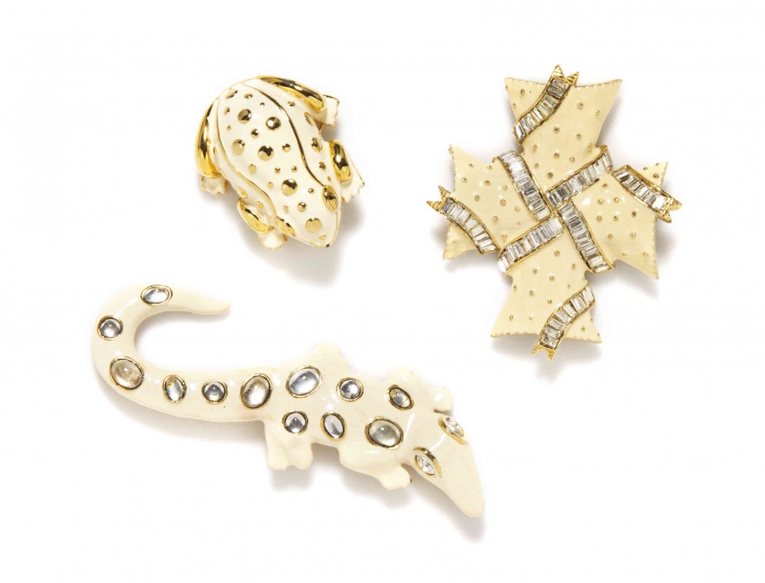 A Group of Three Kenneth Jay Lane Cream Enamel: A Group of Three Kenneth Jay Lane Cream Enamel Brooches, comprised of a frog, a salamander and a cross each with goldtone and rhinestone embellishments. Salamander and frog stamped: Kenneth Lane. Cros
