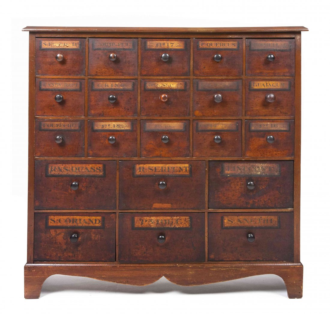 An American Stenciled Apothecary Chest, Height 35 3/4 x: An American Stenciled Apothecary Chest, having a rectangular top over conforming case enclosing an arrangement of twenty-one drawers, each stenciled with various names, raised over a shaped apron and 