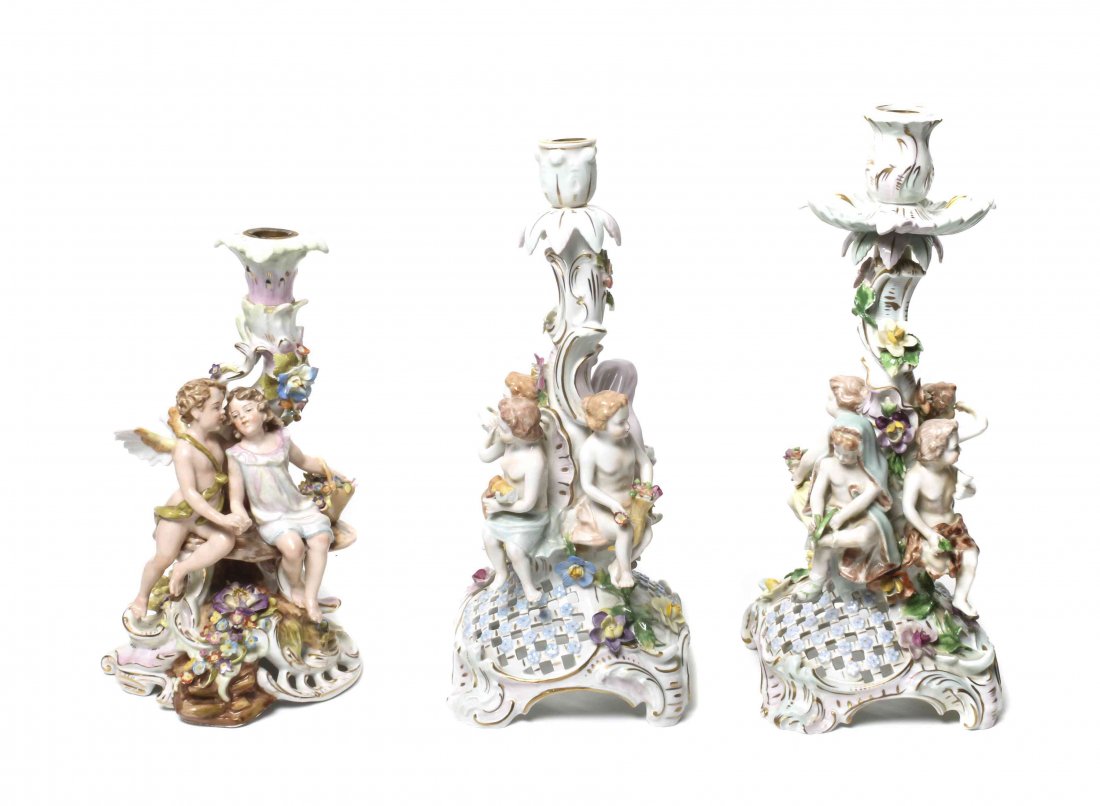 A Pair of Dresden Porcelain Candlesticks, Height of: A Pair of Dresden Porcelain Candlesticks, each floral and putti decorated as allegories of the seasons, raised on a lattice form base with scroll feet; together with another similar Dresden stick. Hei