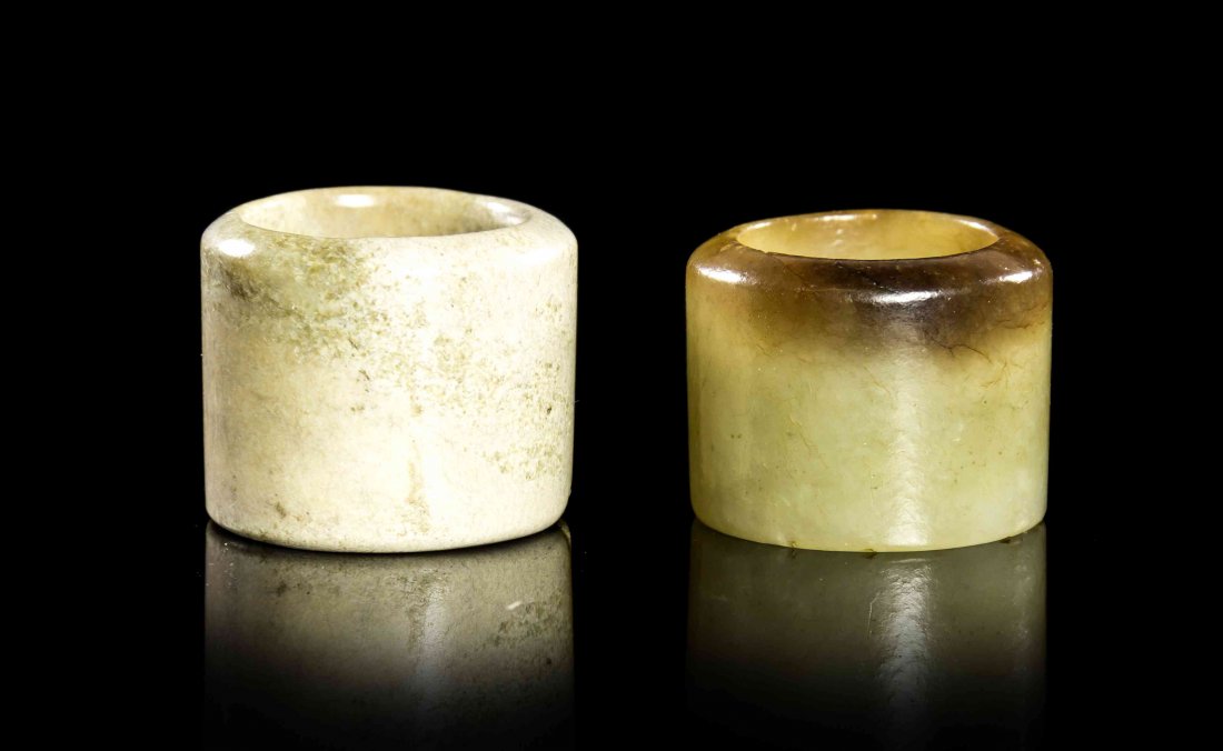 Two Carved Jade Archer's Rings, Height of taller 1: Two Carved Jade Archer's Rings, one of a chicken bone stone, the other of mottled mutton fat and celadon stone. Height of taller 1 inch.