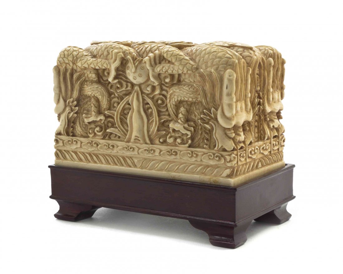 A Chinese Carved Ivory Seal Stamp, Width 5 inches.: A Chinese Carved Ivory Seal Stamp, relief carved depicting downward facing dragons pursuing the flaming pearl on a ground of ruyi clouds centered by a mountain peak, above a band of ruyi clouds and a