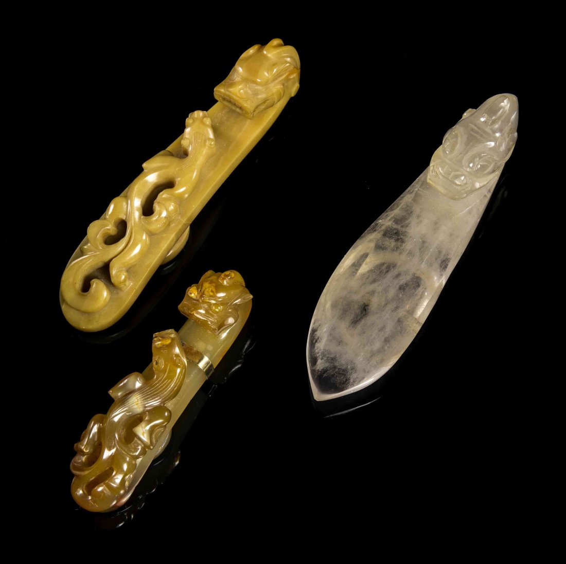 Three Chinese Carved Hardstone Belthooks, Width of: Three Chinese Carved Hardstone Belthooks, one rock crystal, one cafe-au-lait hardstone, one carnelian agate set in 14K gold as a pendant. Width of wider 3 3/4 inches.