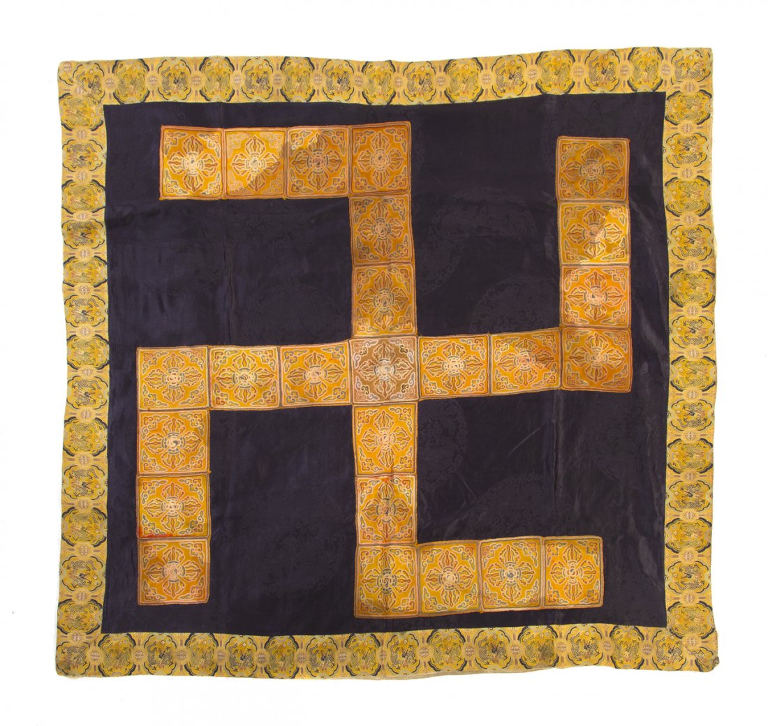 A Chinese Buddhist Embroidered Silk Panel, Height 43: A Chinese Buddhist Embroidered Silk Panel, of squared form, depicting a wan symbol comprised of double vajra squares, on a navy blue patterned silk ground, within embroidered silk borders having shape