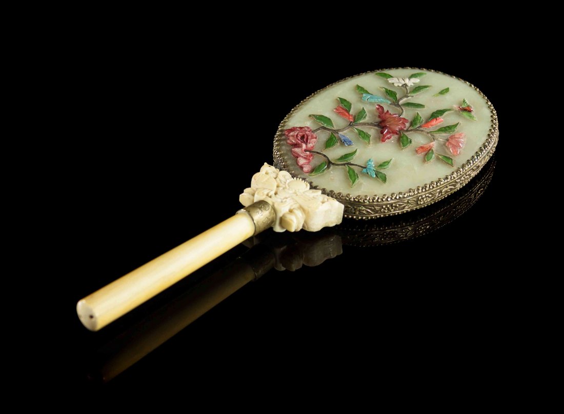 A Chinese Hand Mirror, Length 11 inches.: A Chinese Hand Mirror, of oval form, having hardstone floral decoration laid on a celadon hardstone back, with an ivory handle joined by an ivory carving depicting addorsed birds. Length 11 inches. Pr