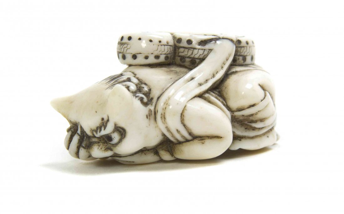 A Carved Ivory Oni Netsuke, Height 2 inches.: A Carved Ivory Oni Netsuke, the oni depicted bearing a group of drums, signed. Height 2 inches. Property from the Collection of Dr. J. Don Nelson, Fargo, North Dakota Provenance: Purchased circa 1950