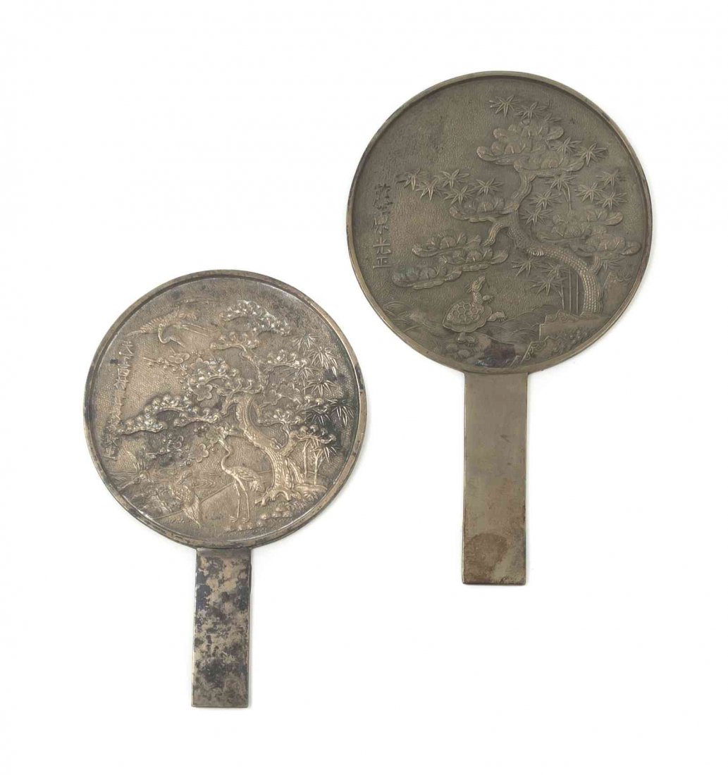 Two Japanese Silvered Bronze Hand Mirrors, Height of: Two Japanese Silvered Bronze Hand Mirrors, each having relief decoration of knotted pine trees, with raised inscriptions. Height of taller 8 7/8 inches.