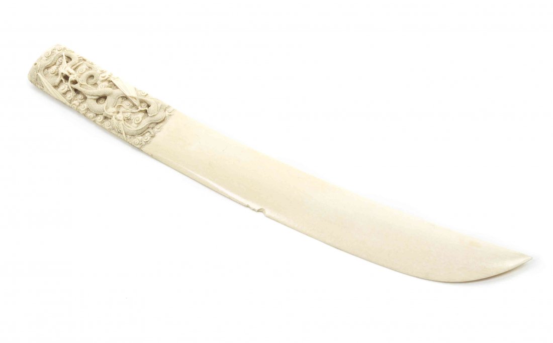 A Japanese Carved Ivory Paper Knife, Length 16 1/8: A Japanese Carved Ivory Paper Knife, having a tapering blade and the handle with a relief carved dragon on a ground of scrolled clouds, bearing signature cartouche. Length 16 1/8 inches.
