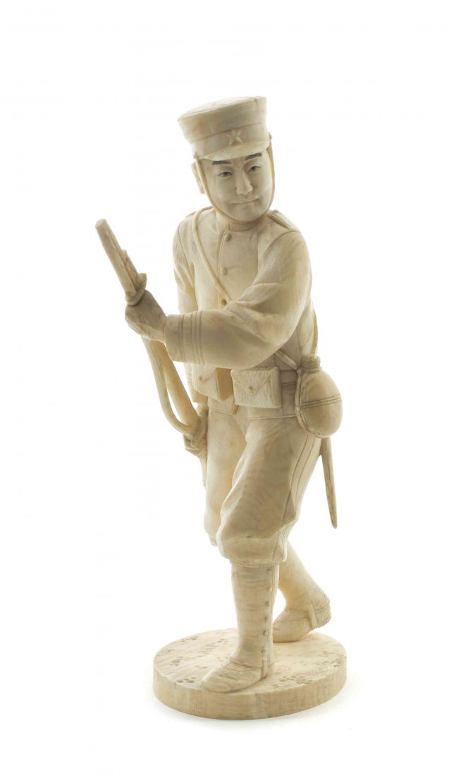 A Japanese Carved Ivory Okimono of a Soldier, Height: A Japanese Carved Ivory Okimono of a Soldier, the figure depicted in uniform and bearing a weapon, with a canteen and implements strapped to his belt, raised on a rounded base. Height overall 6 1/2 in