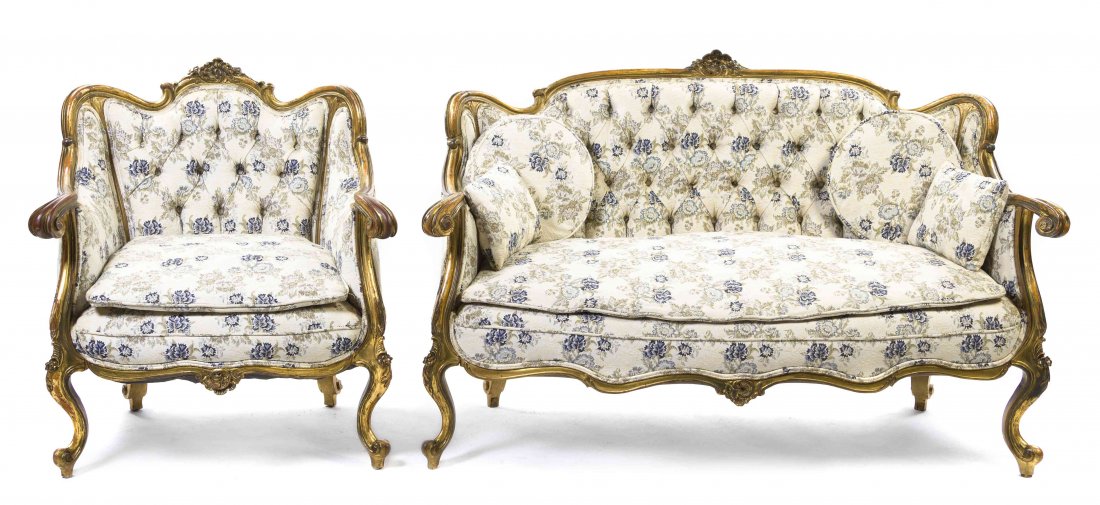 A Louis XV Style Giltwood Parlor Suite, Height of: A Louis XV Style Giltwood Parlor Suite, comprising a bergere and a settee, each with a carved foliate crest over the tufted back and upholstered sides and seat, raised on cabriole legs, ending in scro