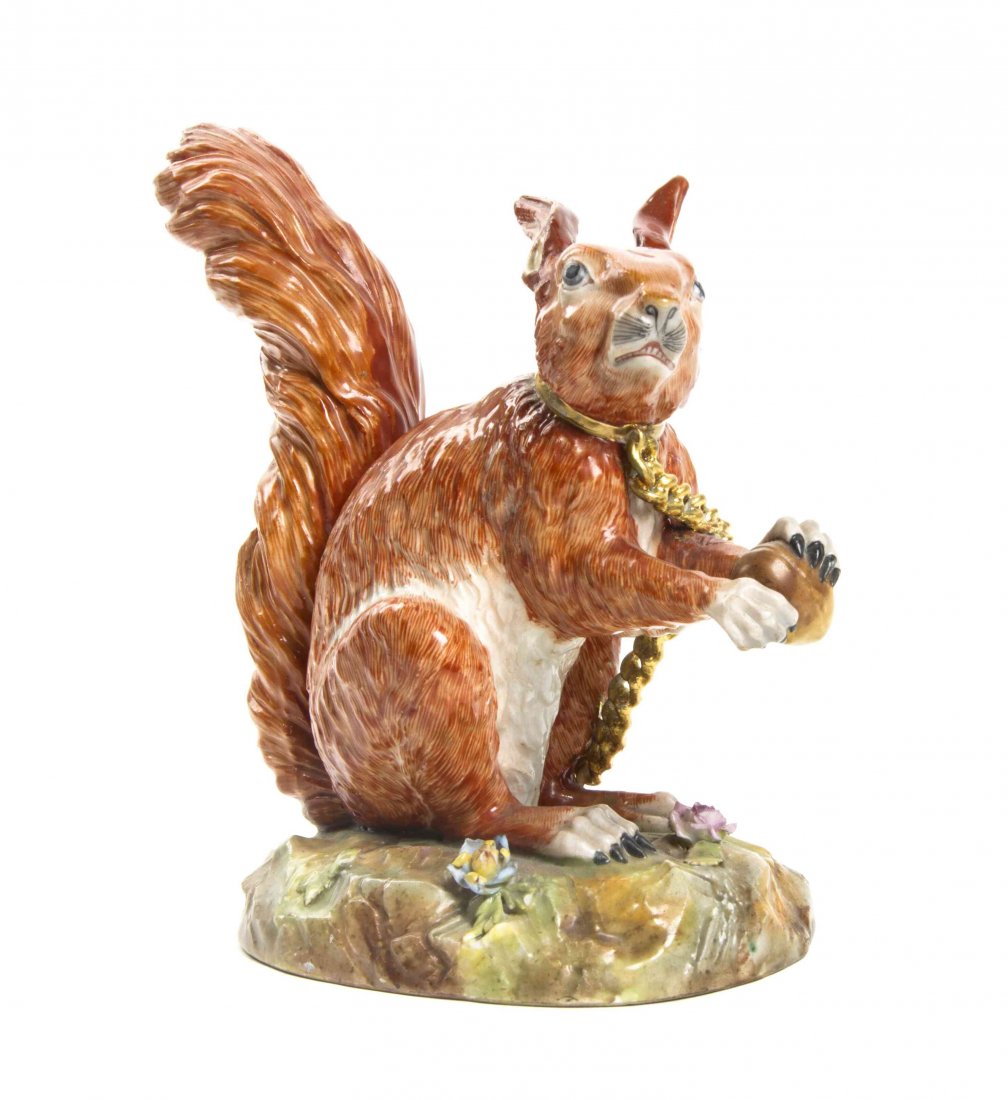 A German Porcelain Animalier Figure, Carl Thieme: A German Porcelain Animalier Figure, Carl Thieme (1816-1888), depicting a chained squirrel clutching a nut raised on an oval floral naturalistic ground, having maker's mark in underglaze blue. Height 