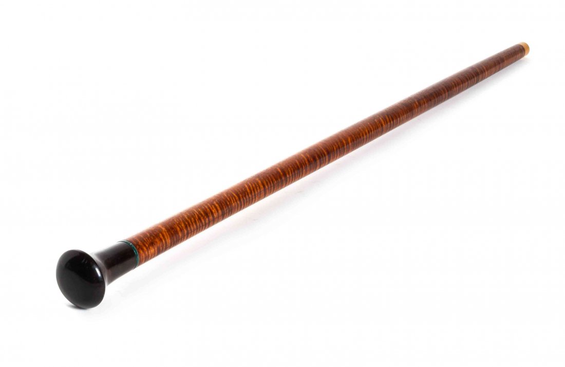 A Contemporary Carved Wood Walking Stick, Length of: A Contemporary Carved Wood Walking Stick, having an ebonized knob handle, on a tiger maple shaft with a maple tip. Length of handle 3 x length overall 35 1/4 inches.