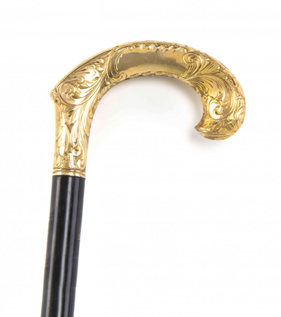 An American Chased Gold Handled Cane, Redlich & Co.,: An American Chased Gold Handled Cane, Redlich & Co., late 19th century, having a crook handle with an ebonized shaft engraved Mr. Clawson, ending in a German sterling silver ferrule with a steel tip. 