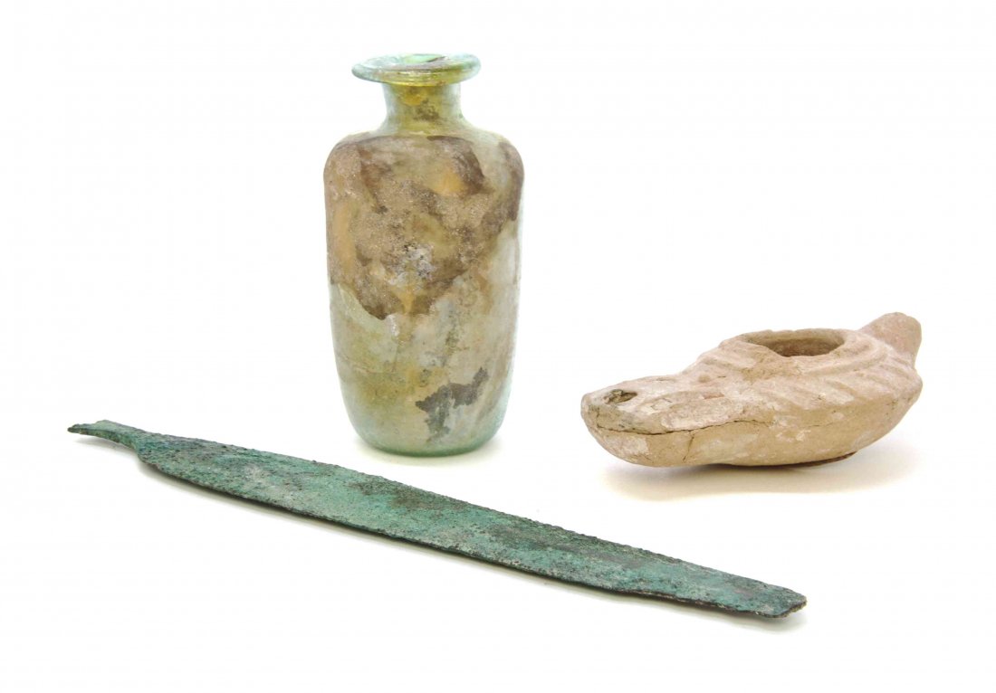 A Collection of Mediterranean Antiquities, Length of: A Collection of Mediterranean Antiquities, comprising a Roman glass bottle, a Luristan spear point and a Palestinian oil lamp. Length of longest 8 7/8 inches. Property from the Collection of a Lady, O