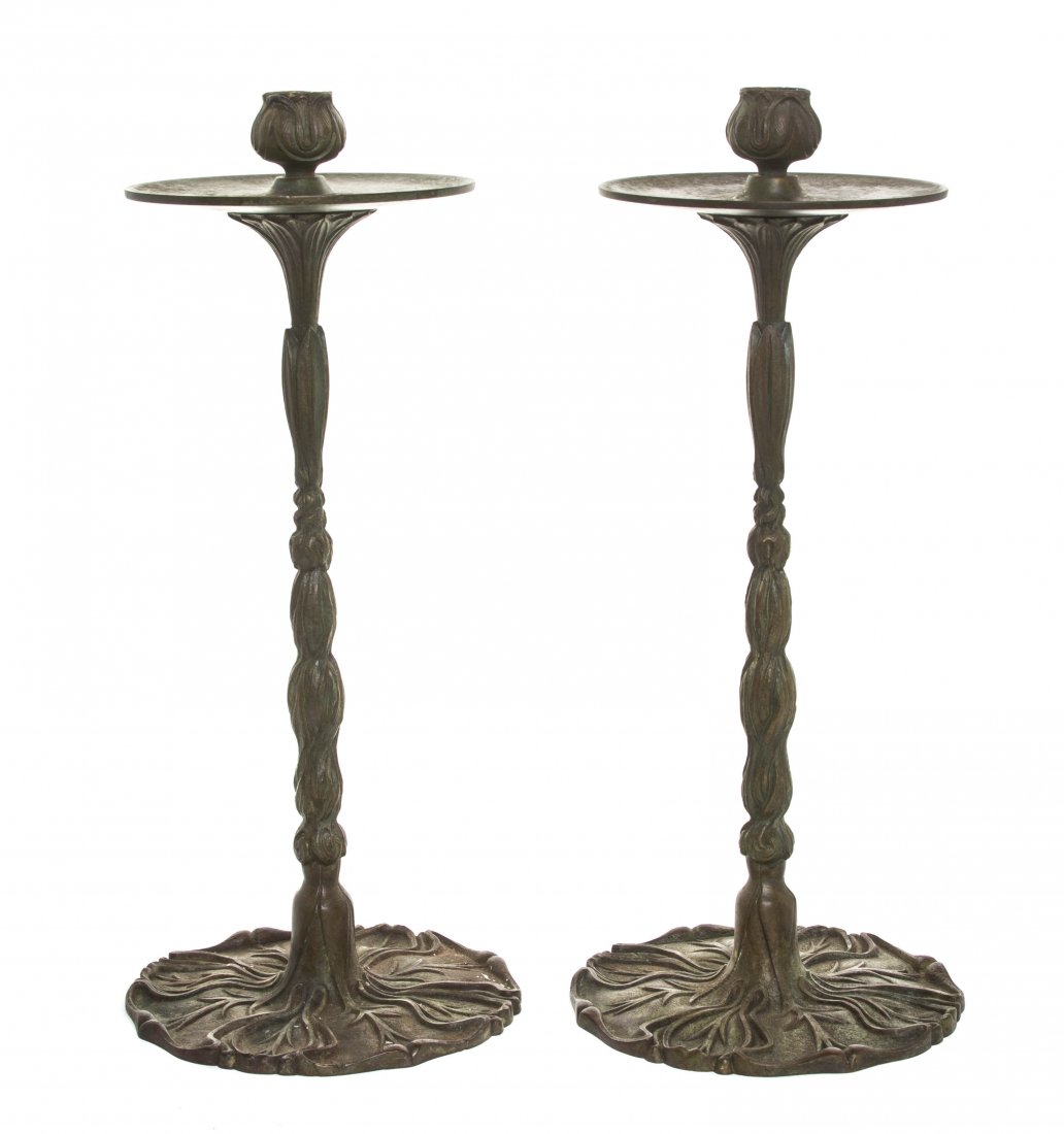 A Pair of Tiffany Studios Bronze Candlesticks, Height: A Pair of Tiffany Studios Bronze Candlesticks, each with a floriform candle cup and a foliate cast stem, raised on a circular base, stamped Tiffany Studios New York. Height 12 1/2 inches.