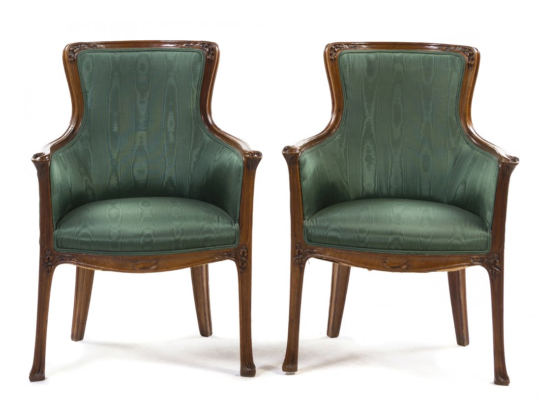 A Pair of French Art Nouveau Walnut Bergeres,: A Pair of French Art Nouveau Walnut Bergeres, attributed to Hector Guimard, each having an upholstered back and seat within a floral carved frame, raised on square tapering legs. Height 36 1/4 inches.