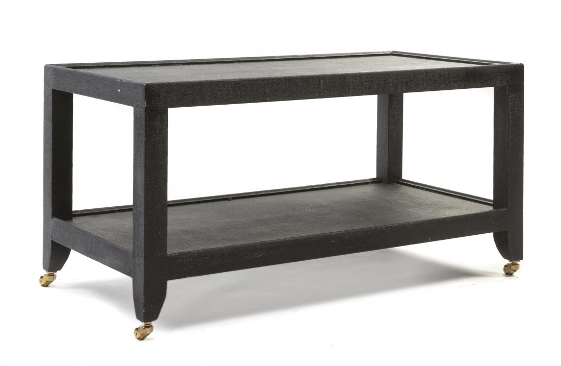 A Karl Springer Veneered Low Table, (American,: A Karl Springer Veneered Low Table, (American, 1931-1991), having a painted fabric veneer with a rectangular top over square form legs joined by a medial shelf, further raised on casters, with plaque