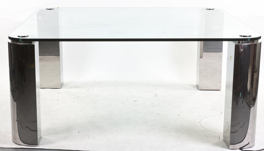 A Glass and Steel Dining Table, Height 29 3/4 x width: A Glass and Steel Dining Table, the square glass top with rounded corners, raised on wedge shaped legs. Height 29 3/4 x width 66 1/8 x depth 66 1/8 inches. Property from the Collection of Andrew Baron