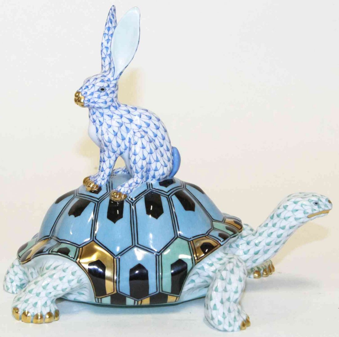 A Herend Porcelain Tortoise and Hare Figurine, Height 8: A Herend Porcelain Tortoise and Hare Figurine, with gilt highlights and fishnet decoration throughout. Height 8 inches. Property from the Estate of Louis M. and Linda M. Byron, Tucson, Arizona