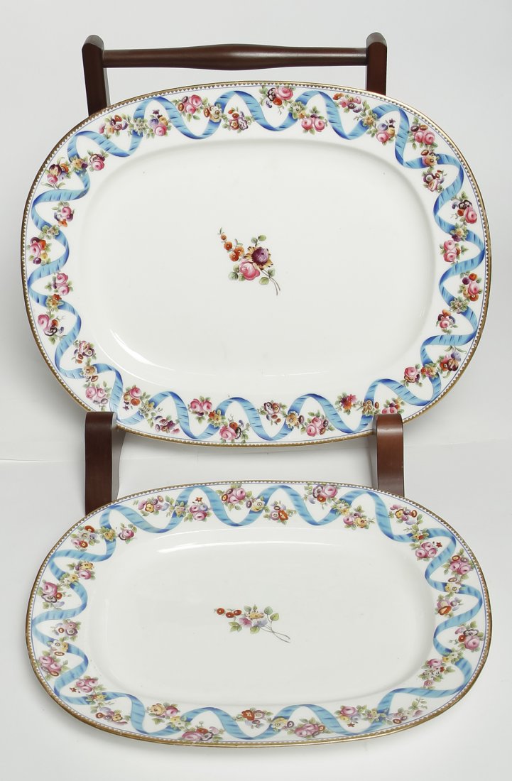 Two Minton Porcelain Platters, Diameter of larger 14: Two Minton Porcelain Platters, each of oval form with ribbon and floral decoration on a white ground. Diameter of larger 14 1/8 x 11 1/8 inches.