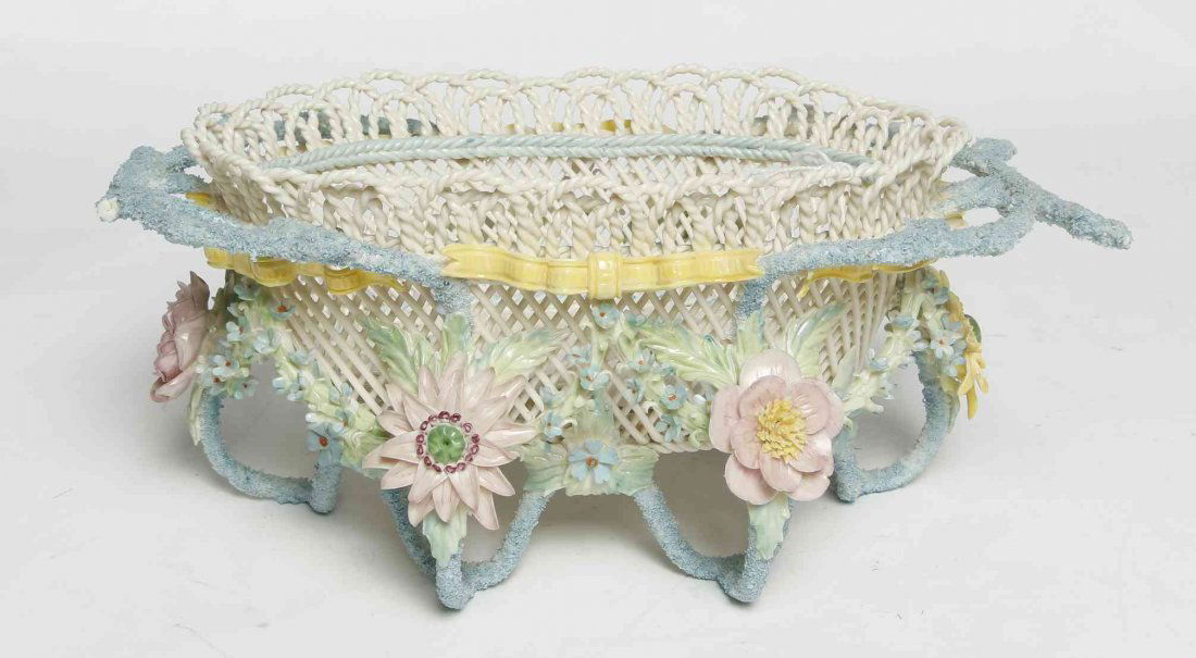 A Belleek Rathmore Basket, Width 11 inches.: A Belleek Rathmore Basket, 1985-1989, having four strands, of oval form with applied floral, ribbon and coral decoration to the exterior, raised on coral form legs, impressed Belleek R Ireland A5 to b