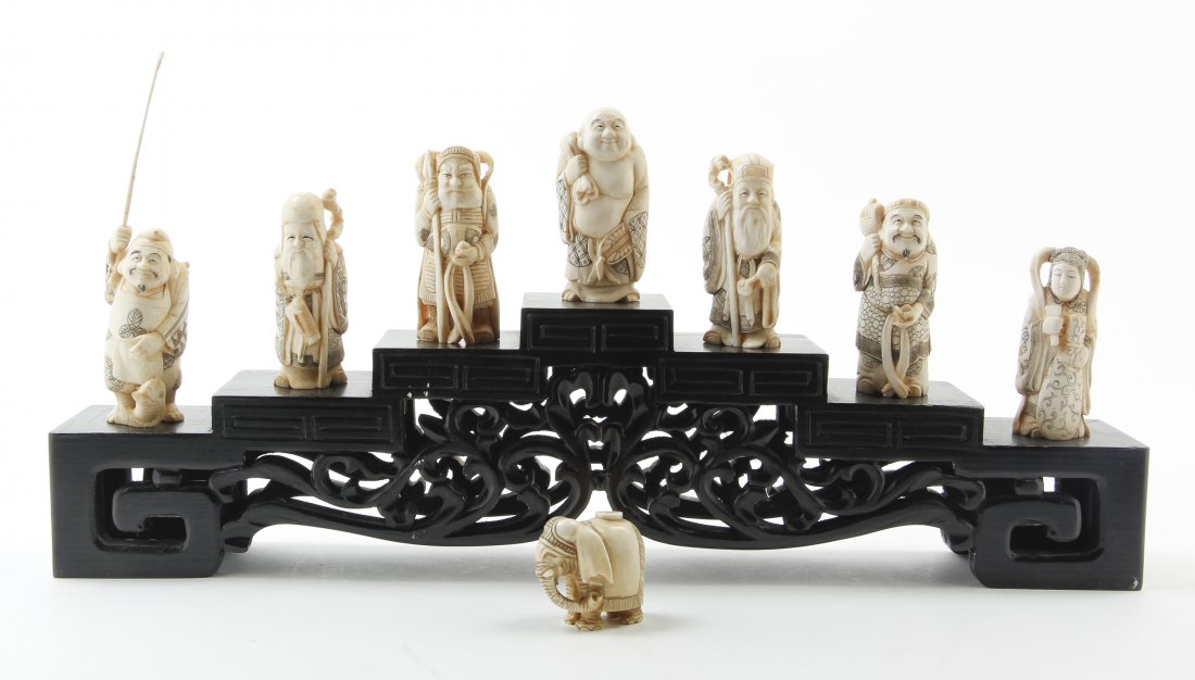 A Set of Seven Japanese Ivory Figures, Average height: A Set of Seven Japanese Ivory Figures, raised on a stepped base, together with a netsuke. Average height of figure 3 1/4 inches. Property from the Estate of Dr. Robert H. Barter, Washington, DC