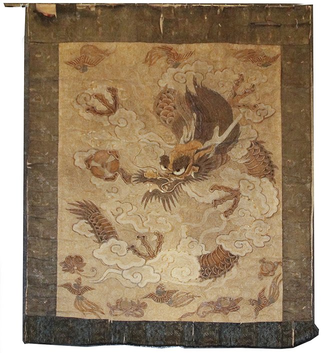 A Japanese Embroidered Panel, Height 67 x width 52: A Japanese Embroidered Panel, worked in couch and other stitches to show a dragon amongst scrolling clouds, mounted to silk. Height 67 x width 52 inches.