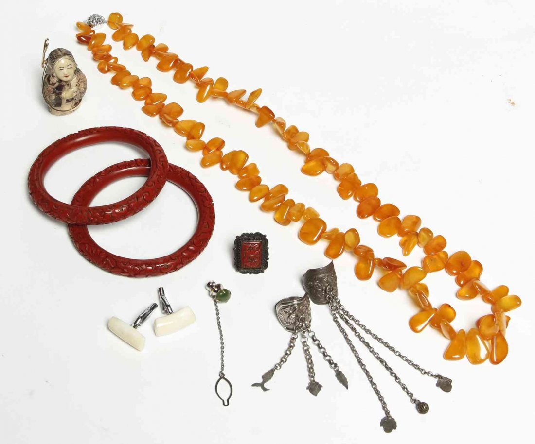 Nine Jewelry Articles, Length of necklace 14 1/2: Nine Jewelry Articles, one orange beaded necklace, three jade pieces, three rings, two cinnabar bracelets, together with a netsuke. Length of necklace 14 1/2 inches.
