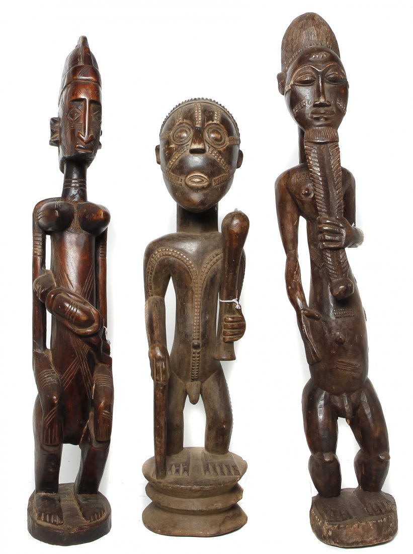 Three African Carved Figures, Height of tallest 35 3/8: Three African Carved Figures, comprising a Baule standing man with a beard, a Hemba standing man with a cane and an axe and a Dogon figure of a standing mother and her child. Height of tallest 35 3/8 