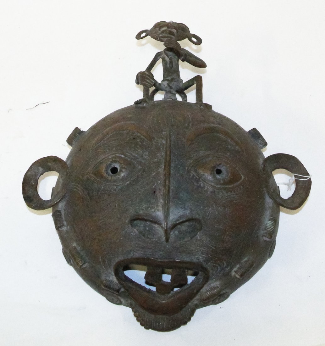 A Cameroon Bronze Mask, Height 14 3/4 inches.: A Cameroon Bronze Mask, Banum, having a round face, surmounted by a seated figure. Height 14 3/4 inches. Property from the Collection of Gerald F. Glaeve, Mount Horeb, Wisconsin