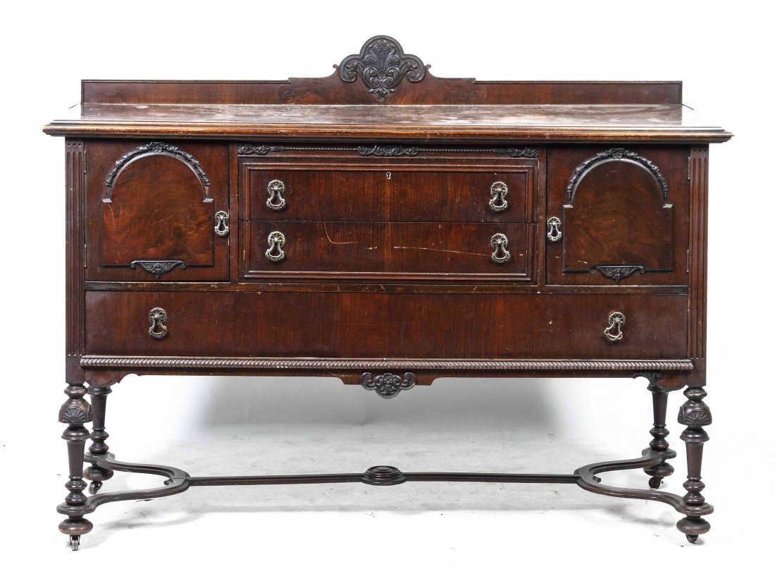 A Renaissance Revival Style Mahogany Server, Height of: A Renaissance Revival Style Mahogany Server, having a rectangular top with a molded edge and floral carved backsplash over a conforming case enclosing two short drawers flanked by a cupboard door to e