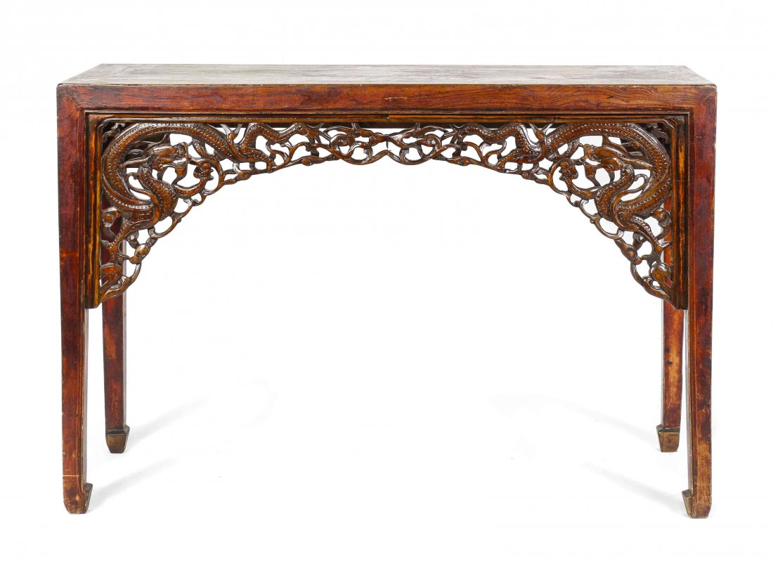 A Chinese Carved Wood Table, Height 34 x width 50 1/4 x: A Chinese Carved Wood Table, having a rectangular top over the open carved apron depicting dragons, raised on block legs ending in elephant feet. Height 34 x width 50 1/4 x depth 17 1/2 inches.