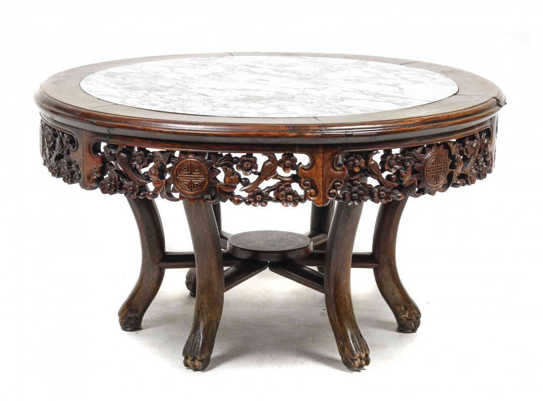 A Chinese Carved Hardwood Pedestal Table, Height 21 x: A Chinese Carved Hardwood Pedestal Table, having a circular top with captured marble above the pierce carved apron depicting bats and birds amongst prunus blossoms around Shou medallions, raised on si