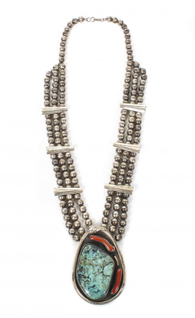 A Zuni Silver, Turquoise and Coral Pendant, Pendant: A Zuni Silver, Turquoise and Coral Pendant, having large turquoise stone and two pieces of branch coral all on triple strand of beads with decorated spacers. Pendant height 3 1/4 x width 2 1/2; chain
